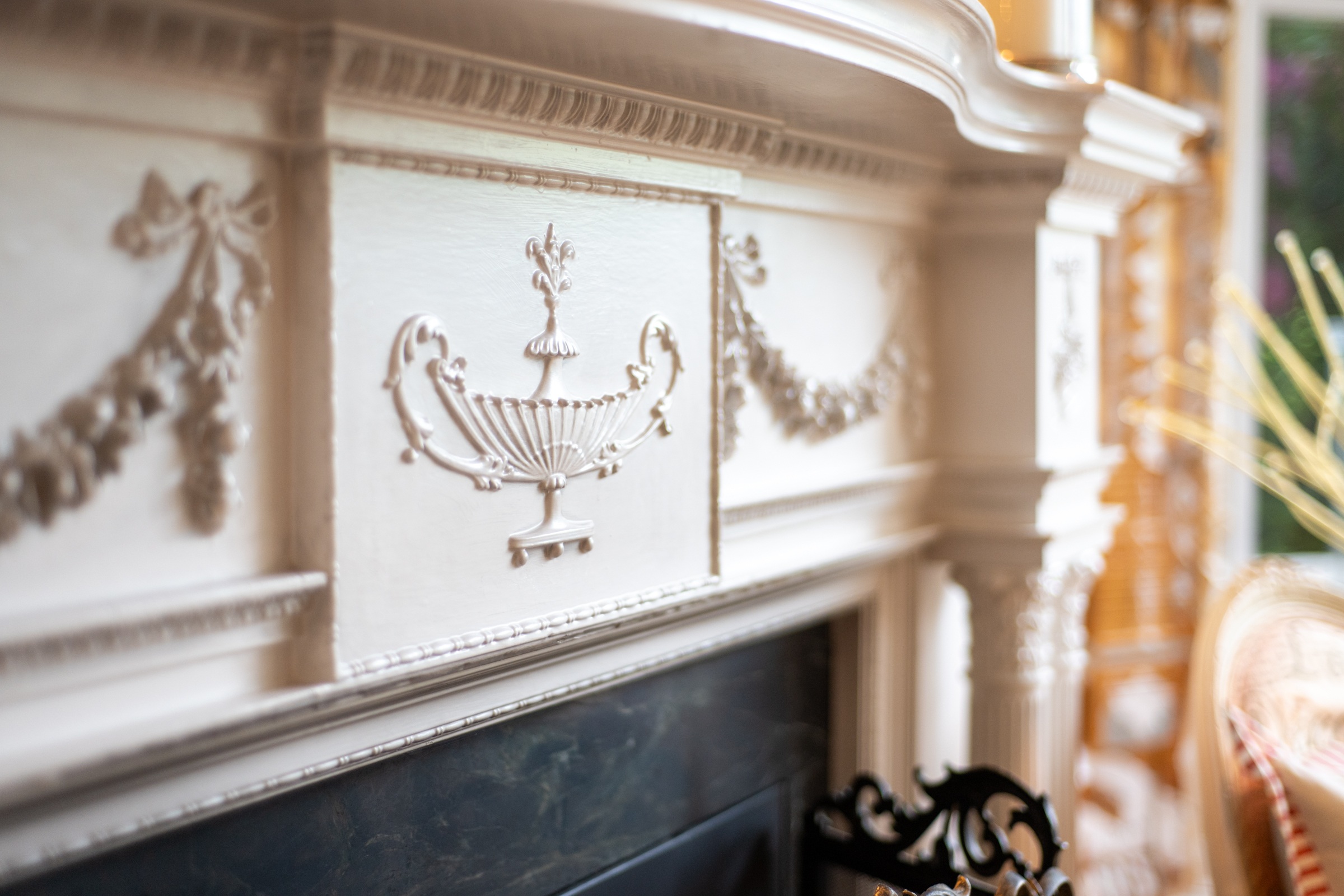 Carved relief on a white fireplace mantel