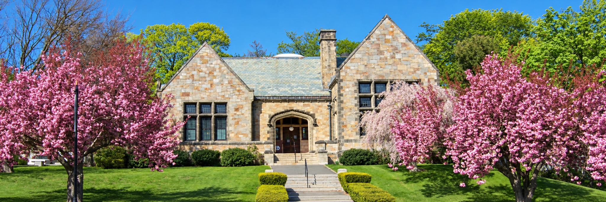 Nahant Public Library with spring flowers and its stone facade